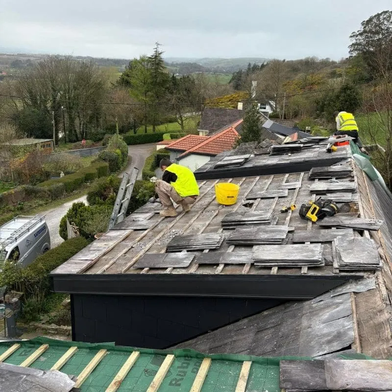 Safeguard roofers stripping natural slate dormer roofs to expose failed membrane