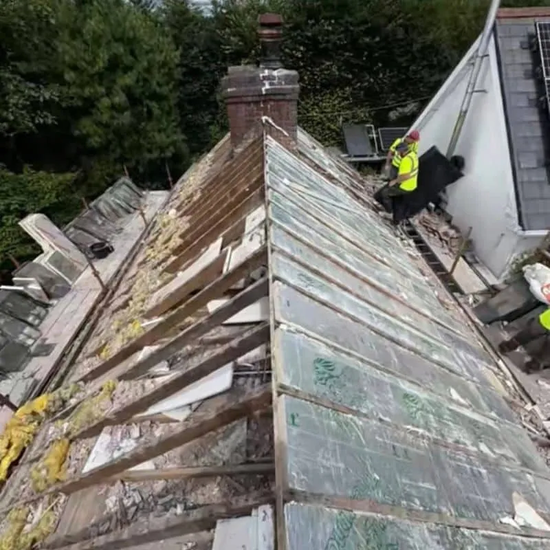 Insulation being installed between roof rafters during slate roof replacement