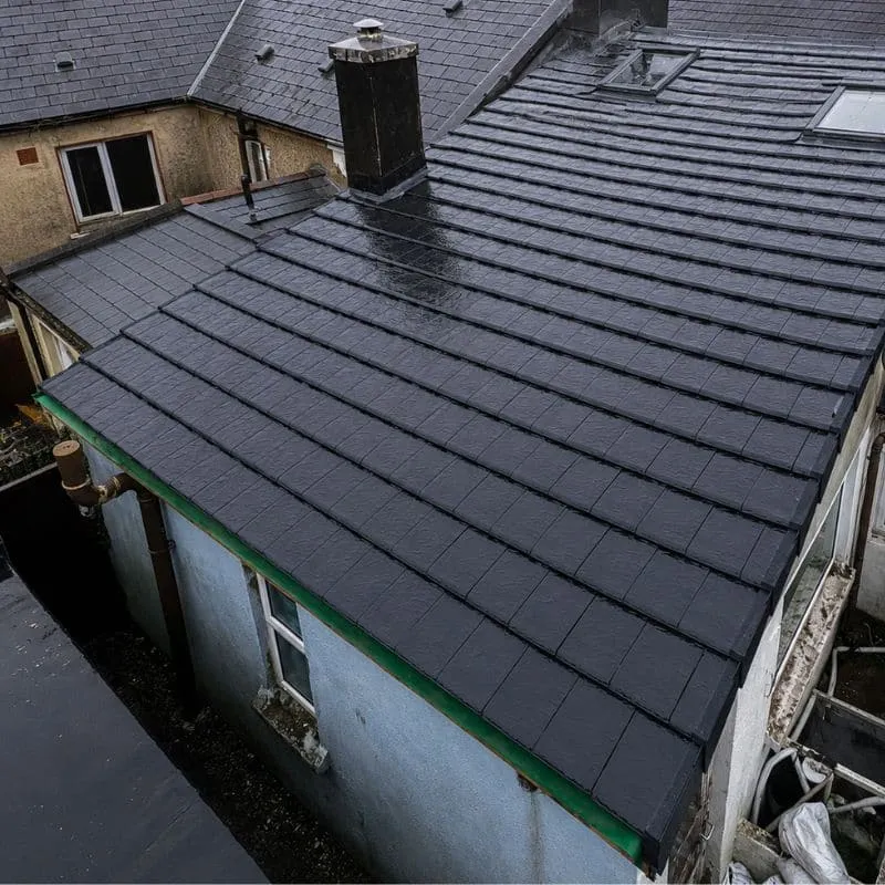 Pitched tiled roof with a chimney, roof windows and adjoining roof junctions