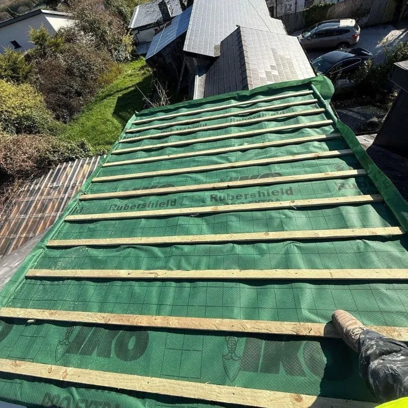 Green roofing membrane and new timber battens fitted across a stripped dormer roof